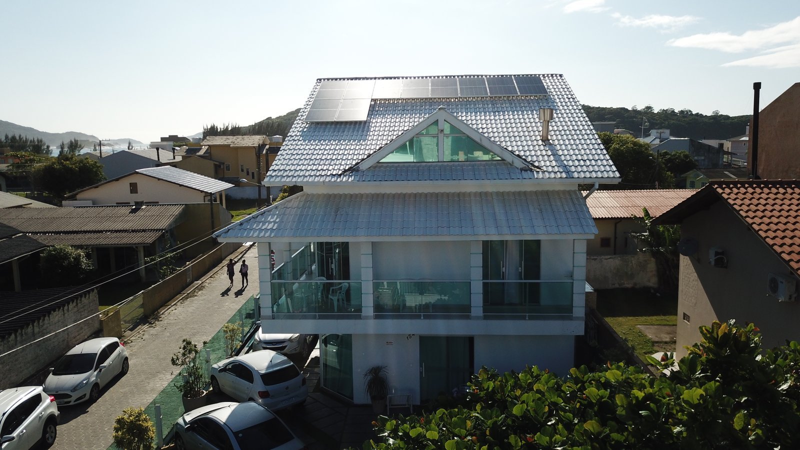 Casa de dois andares com painéis solares instalados no telhado.
